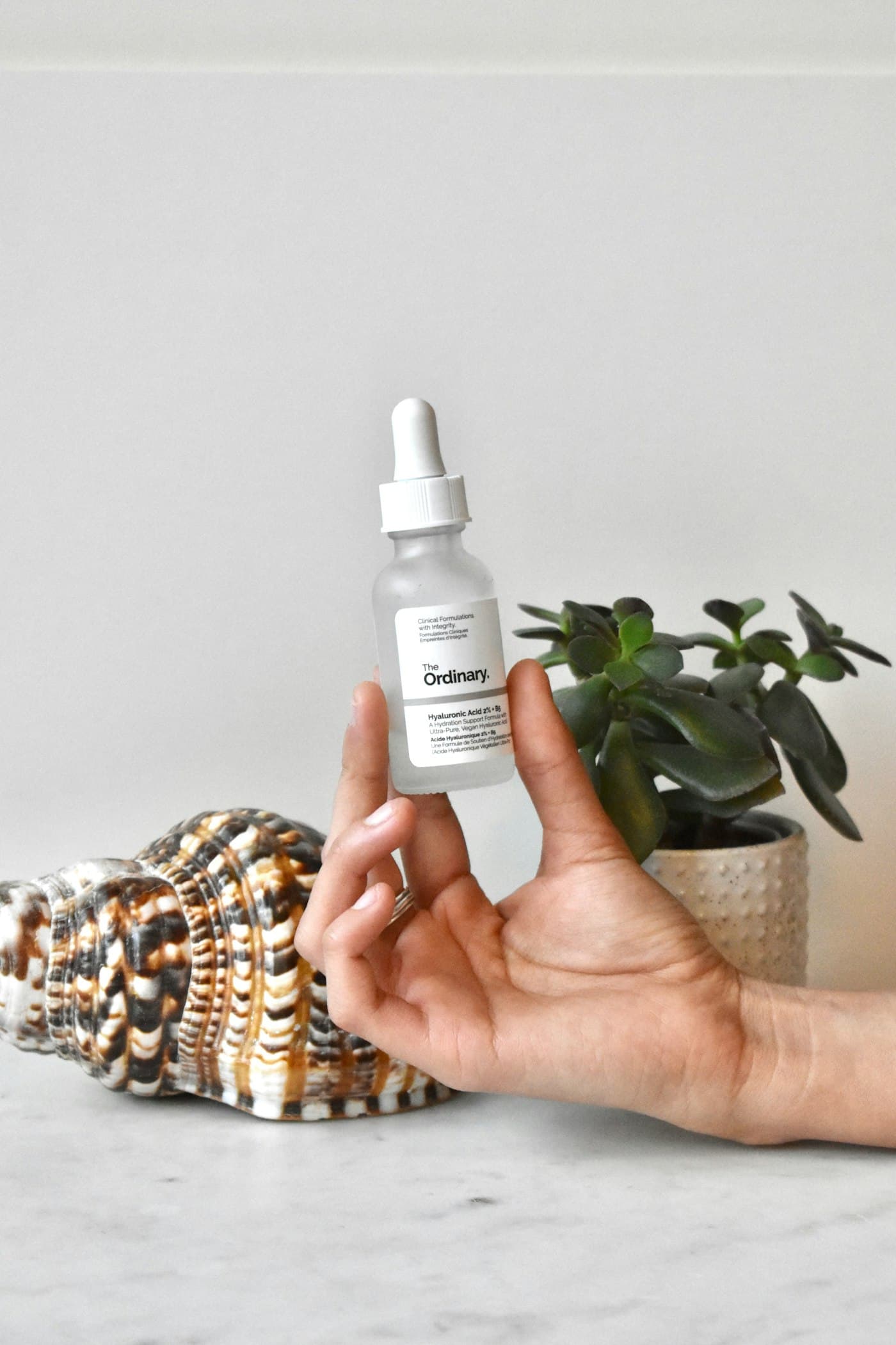 Hand holding a GOYO dropper beside a plant